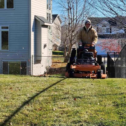 Bryce Taylor mowing a lawn in the Des Moines metro on a commercial stand-on mower